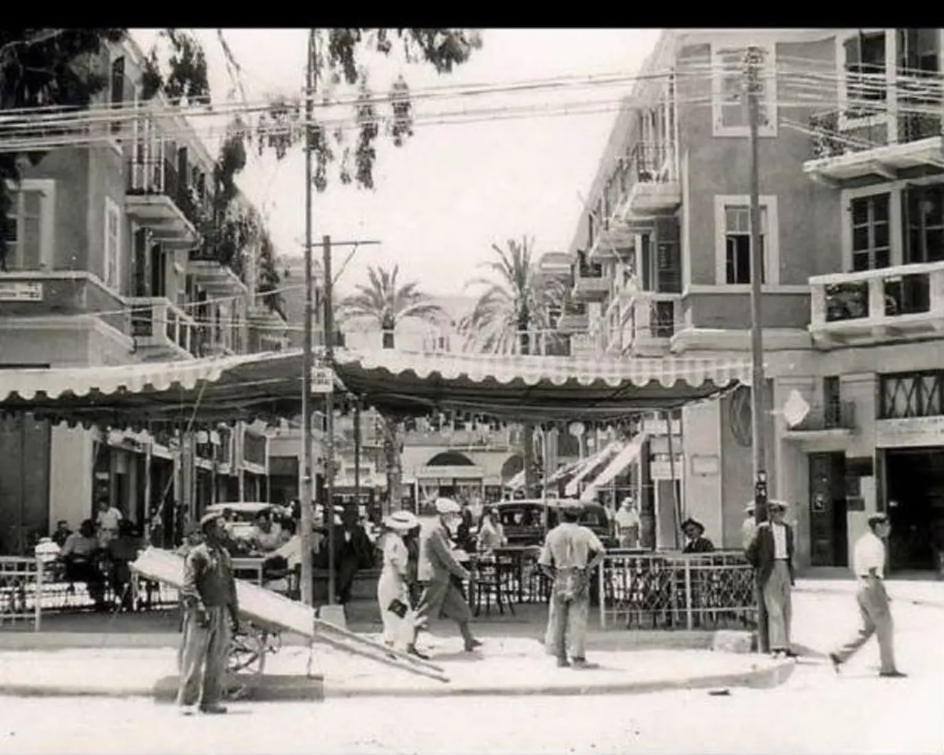 קפה מתחת לסוכך בד, בשעה שבה הנמל נדם.